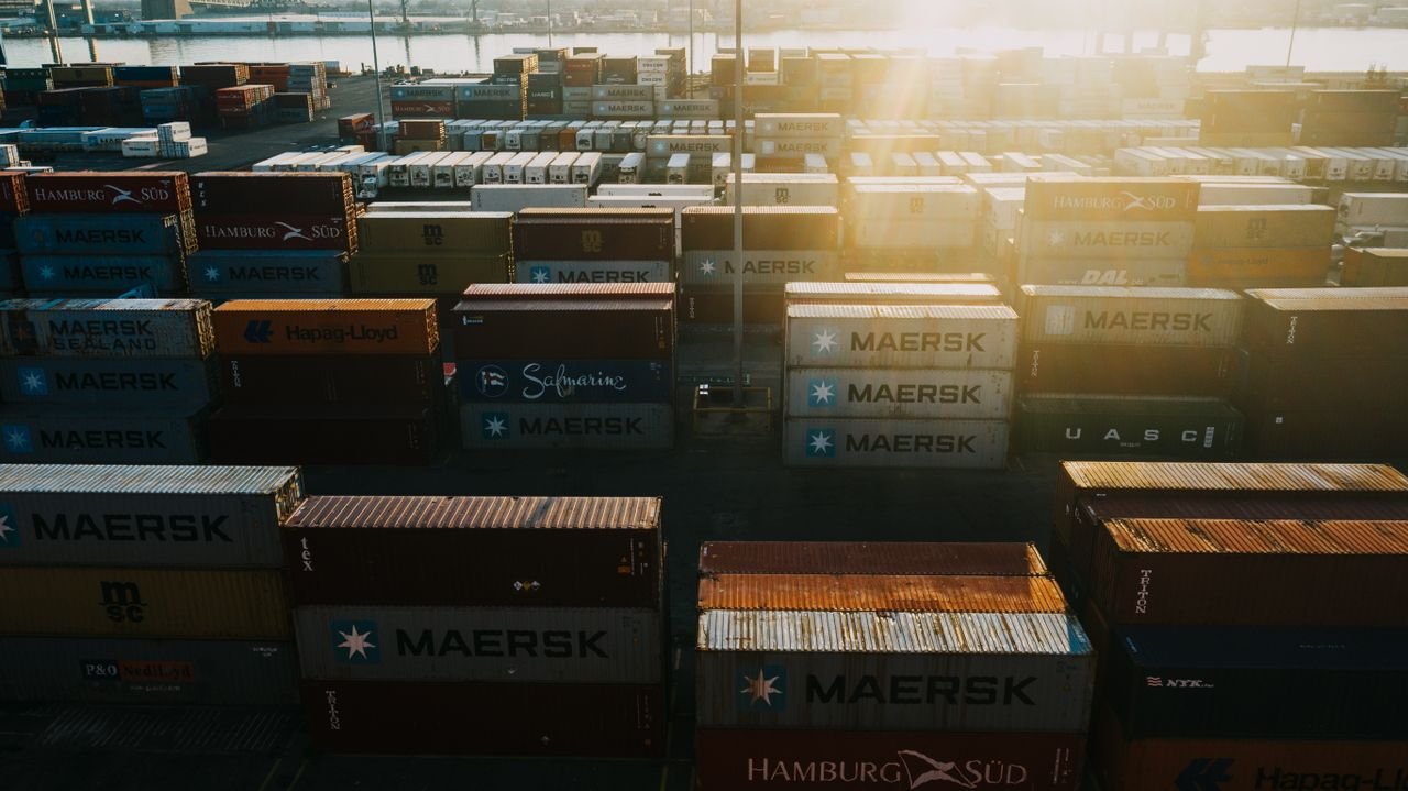 Crafting Captivating Headlines: Your awesome post title goes here From above of different colored cargo containers placed in rows in industrial district in back lit